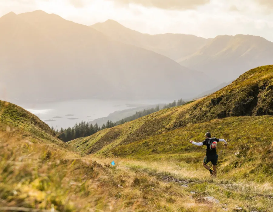 Man running down grassy hill