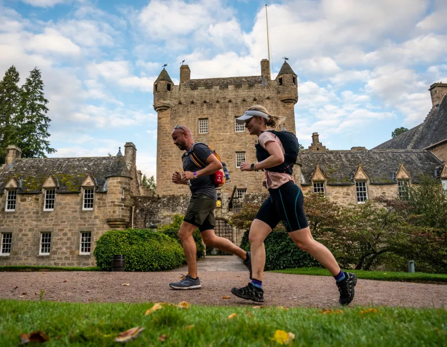 Man and woman running past building