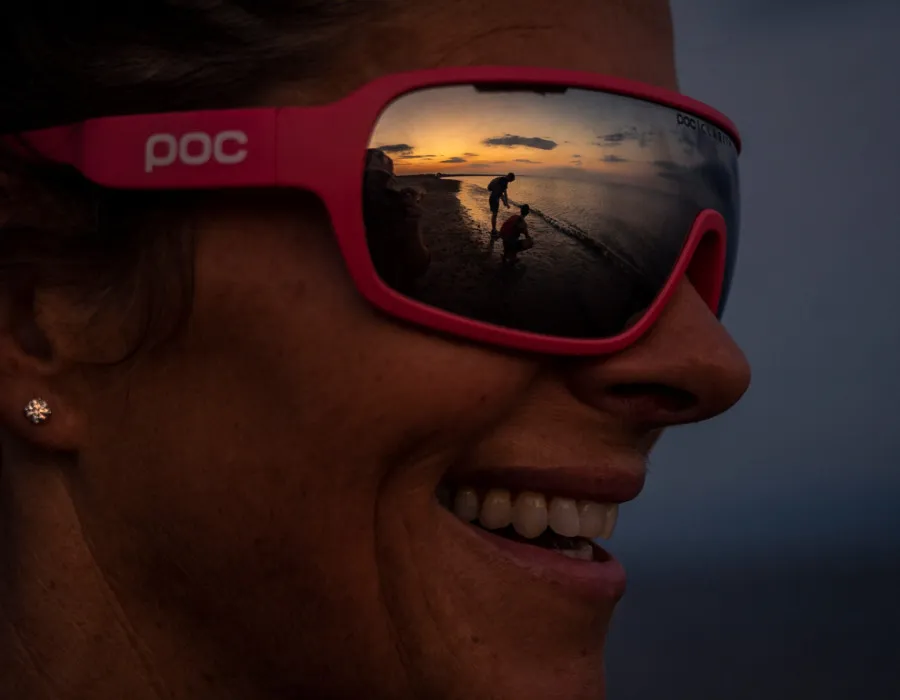 Woman wearing pink sunglasses and smiling