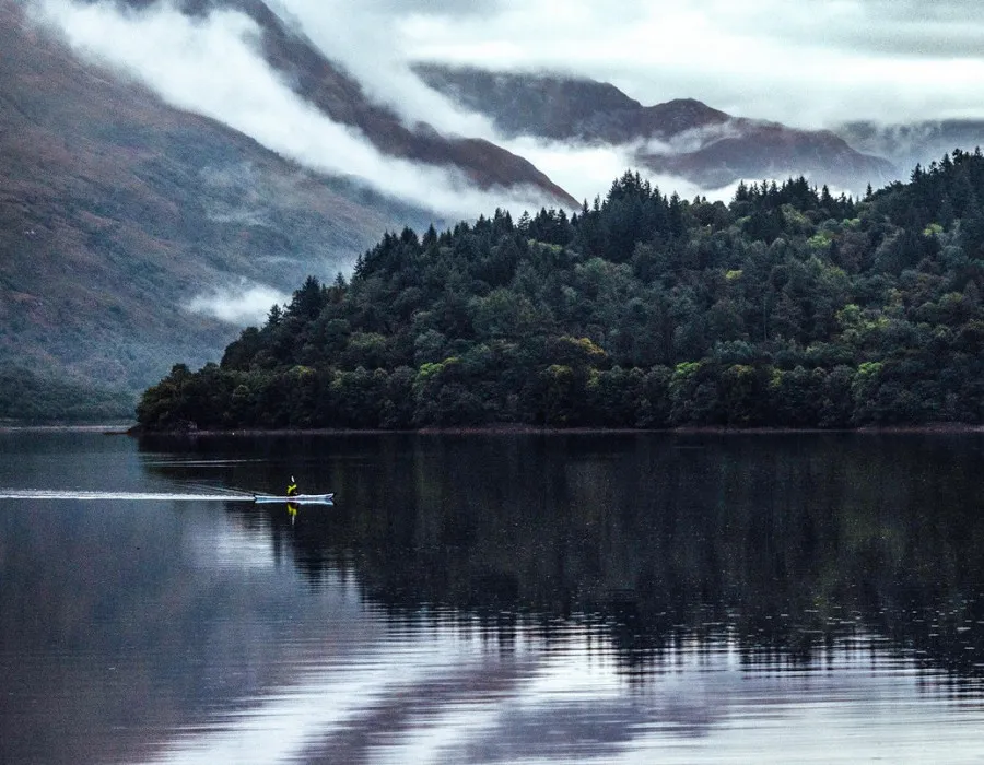 Participant kayaking across dark lake