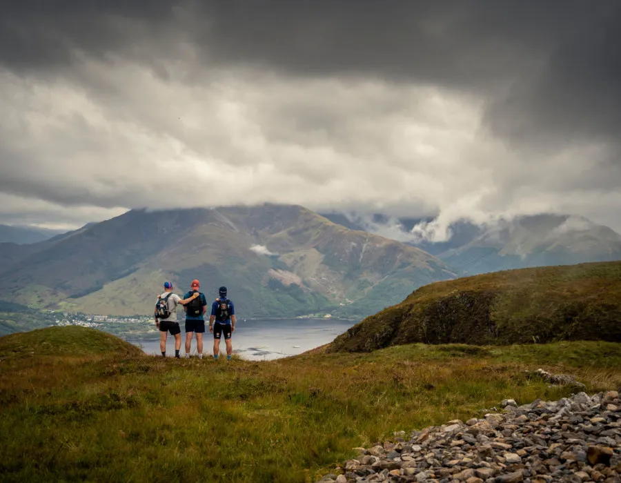 Three people stood, looking out at water below
