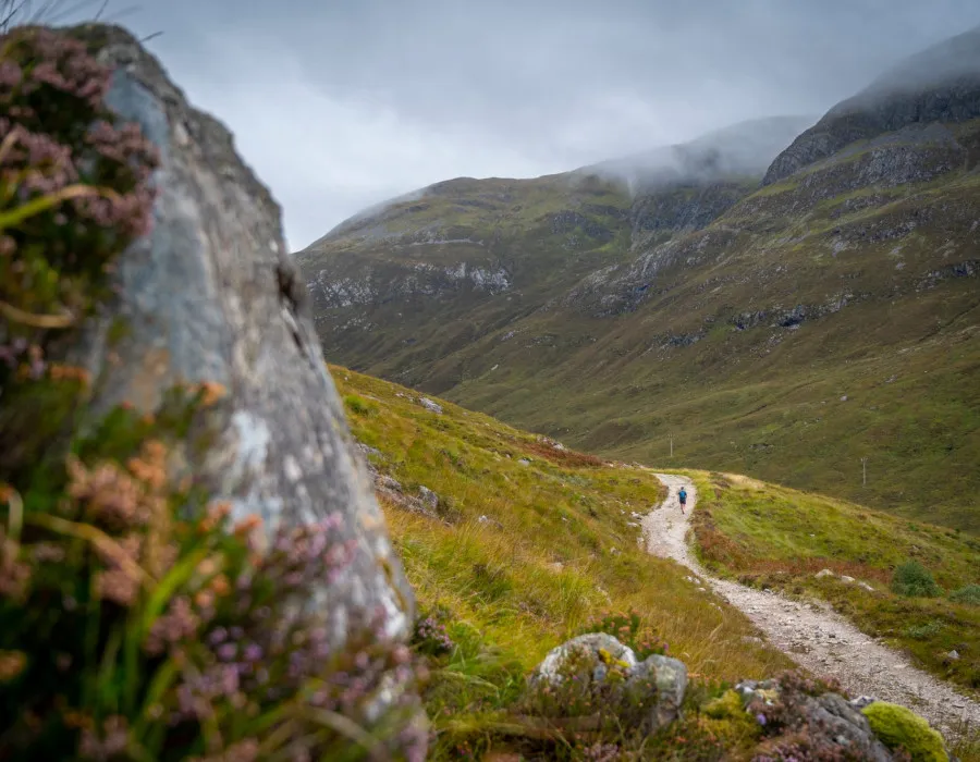 Participant running along track with mountains in background