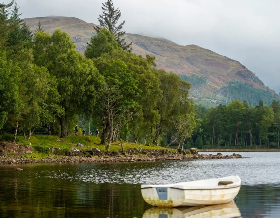 Lone boat sitting in water and participants cycling in background