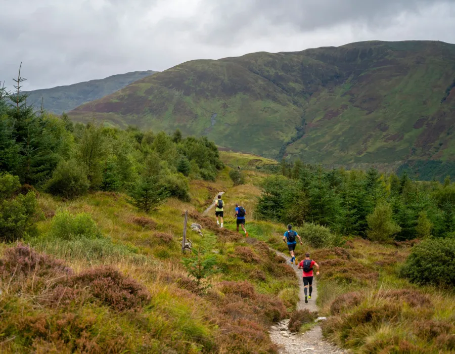 Participants running down track and surrounded by greenery
