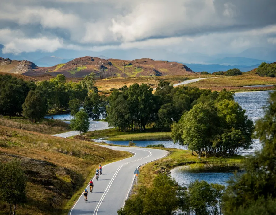 Cyclists riding down winding road