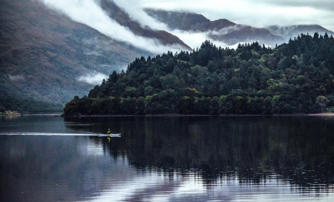 Participant kayaking across dark lake